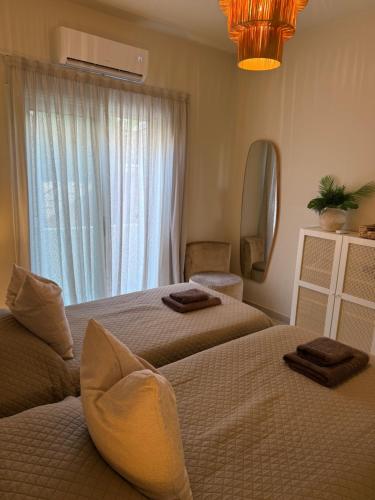 a hotel room with two beds and a window at Nikos Latchi Harbour in Lachi