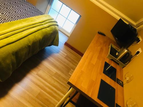 a bedroom with a bed and a wooden table at Pisgah Guesthouse Snowdonia in Blaenau-Ffestiniog
