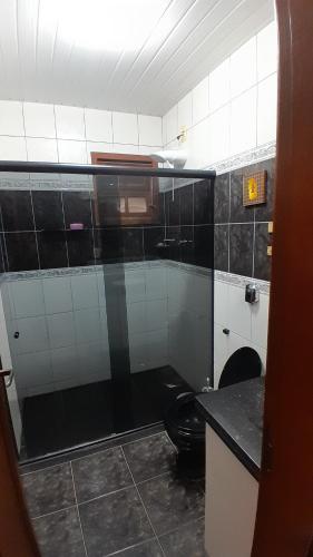 a bathroom with a black and white tiled wall at Natureza e sossego in Volta Redonda