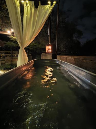 a swimming pool at night with a white curtain at Le Querce Dell'Etna B&B in Ragalna
