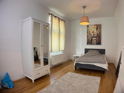 a bedroom with a bed and a dresser and a mirror at Gästehaus urucu in Bornheim