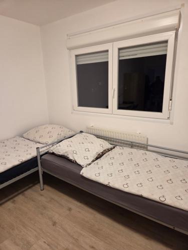 twee bedden in een kamer met een raam bij CityCube Apartment in München
