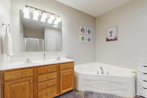 a bathroom with a tub and a sink and a tub and a mirror at Klonteska B5 in Beech Mountain