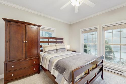 a bedroom with a bed and a dresser and windows at Klonteska B5 in Beech Mountain