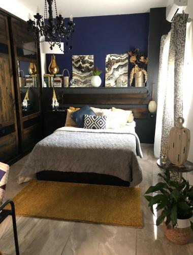 a bedroom with a bed and a blue wall at Hortensia Room A2 in St. Paul's Bay