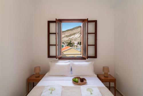 a bed with a window with a bowl of fruit on it at Merry del Mare in Meyisti