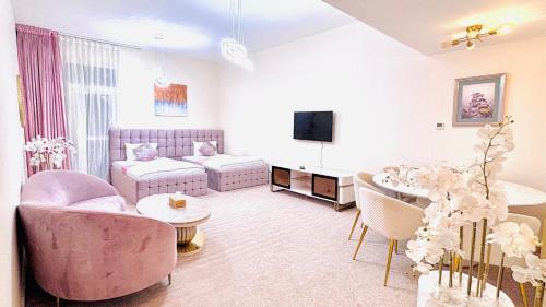 a living room with pink furniture and a table at Sea View Holiday Home with Parking in Ajman 