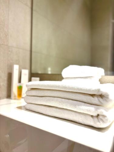 a pile of towels sitting on a table in a bathroom at Canel View Holiday Home with Parking in Ajman 