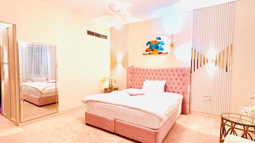 a bedroom with a pink bed and a mirror at Sea View Holiday Home with Parking in Ajman 