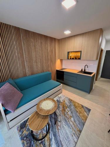 a living room with a blue couch and a sink at Apartmán nad Dolným Kubínom in Dolný Kubín