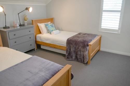 a small bedroom with two beds and a dresser at Balneaire 13 in Albany