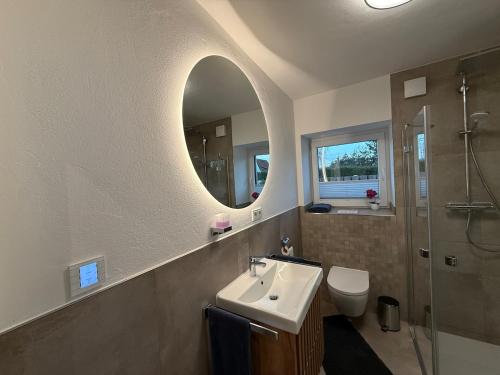 a bathroom with a sink and a toilet and a mirror at Fewo Voßbarg ünnen in Rastede