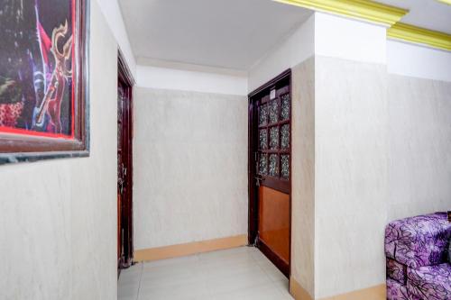 pasillo con puerta y silla en una habitación en SPOT ON Dn Hotel, en Gorwa