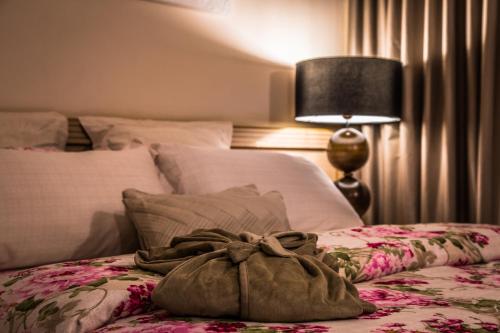 a bed with a bag sitting on top of it at Hotel Golden Park Uberaba in Uberaba