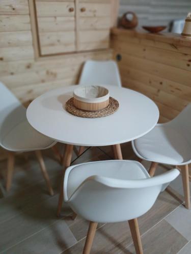 een witte tafel met twee stoelen en een hoed erop bij Apartman Bakic in Kolašin