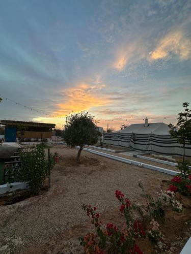 een uitzicht op een gebouw met een zonsondergang op de achtergrond bij منتجع ومزرعة برزان in Ad Diḩwah