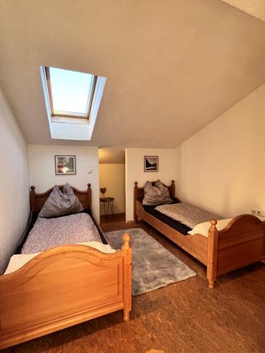 twee bedden in een kamer met een dakraam bij Ferienhaus Praschberg in Niederndorferberg