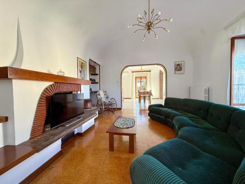 a living room with a green couch and a fireplace at Casa Felice 1910 in Introdacqua