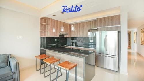 a kitchen with a stainless steel refrigerator and stools at 2B Torre KU 2BR Sofa Bed Private balcony in Puerto Vallarta