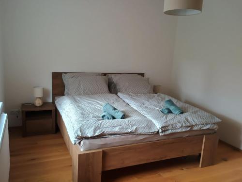 a bed with blue pillows on it in a room at Apartmán Vail in Svoboda nad Úpou