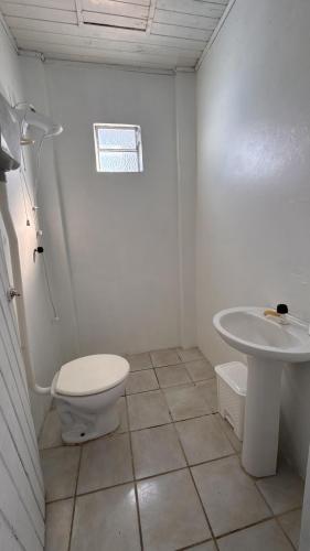 Adegas Bar e Hotel في ساو غابرييل: حمام أبيض مع مرحاض ومغسلة