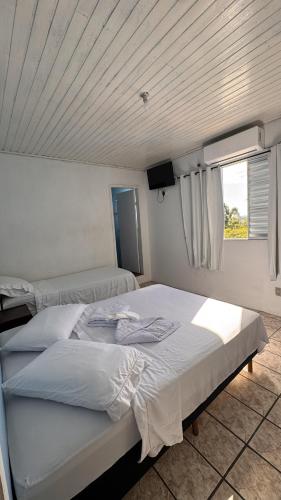 Adegas Bar e Hotel في ساو غابرييل: غرفة نوم بها سريرين ونافذة