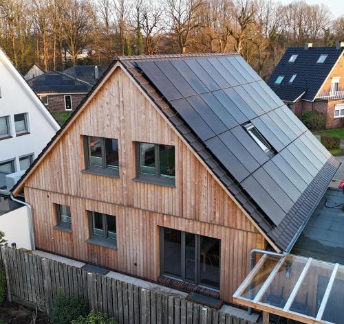 an image of a house with solar panels on it at Fewo Voßbarg ünnen in Rastede