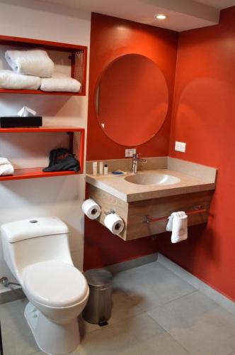 ein Badezimmer mit Toilette und Waschbecken mit Spiegel in der Unterkunft The Place Hotel in Quito