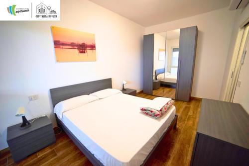 a bedroom with a large bed and a mirror at Comacchio Experience - Ospitalità Diffusa in Lido di Pomposa