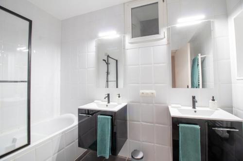 ein weißes Badezimmer mit zwei Waschbecken und einer Badewanne in der Unterkunft Le Rinaldi Loft in Albi