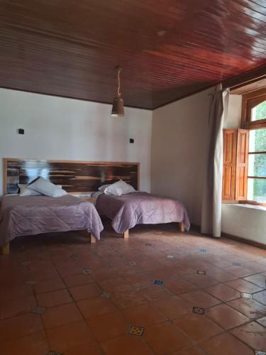 a bedroom with two beds in a room at La Casa Grande in San Cristóbal de Las Casas
