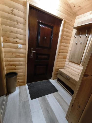 a small room with a wooden door and a rug at Apartman Bakic in Kolašin