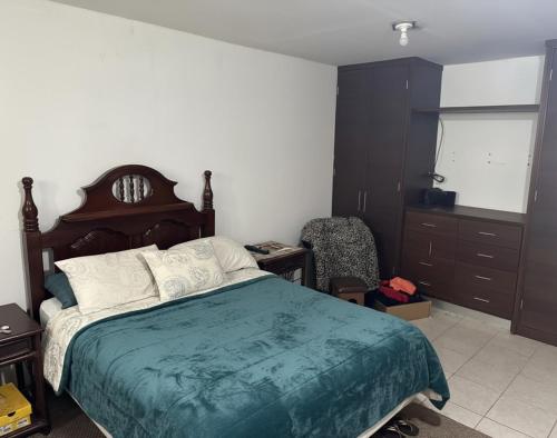 una camera da letto con un letto, una sedia e una finestra di Apartamento Atzompa Oaxaca a Città di Oaxaca
