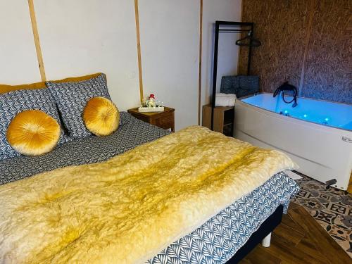 a bedroom with a bed and a bath tub at Le chalet à bulles in Sainte-Marie-au-Bosc