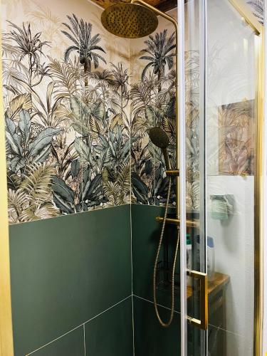 a bathroom with a shower with a mural of plants at Le chalet à bulles in Sainte-Marie-au-Bosc