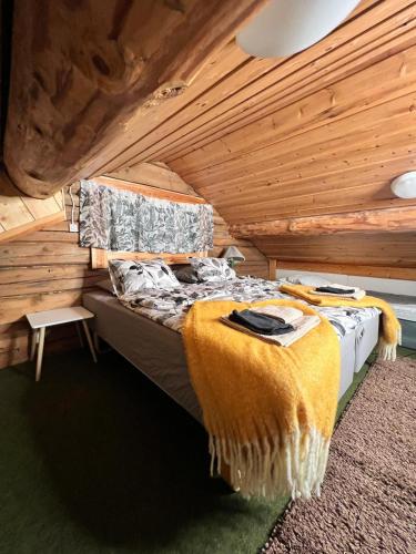 a bed in a room with a wooden ceiling at Kotkanpesä in Ylläs
