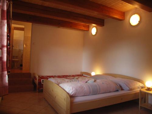 a bedroom with a bed with two lights on the wall at Penzion Javořice in Telč