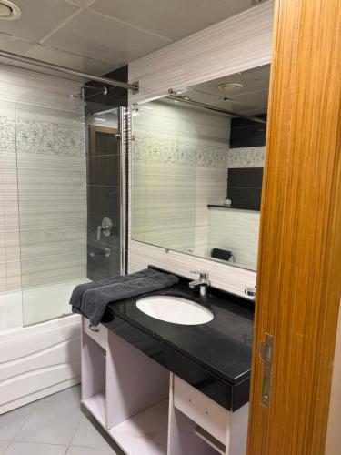 a bathroom with a sink and a shower and a mirror at 2Bed Apartment in Centaurus with City and Margalla views in Islamabad