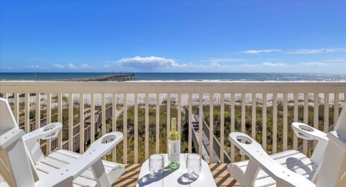 a table and chairs on a balcony with the beach at Drift Away in Topsail Beach