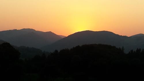 a sunset over a mountain range with the sun setting at Apartment Nepomuk in Kirchberg an der Pielach