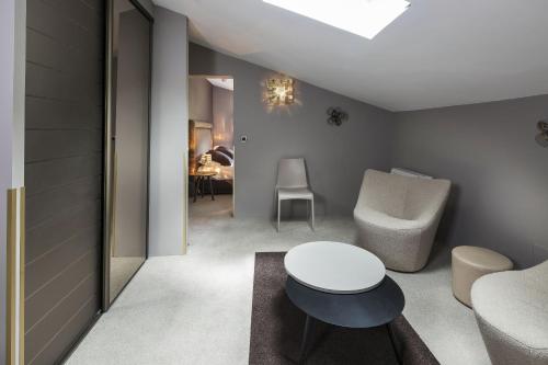 een woonkamer met een tafel en een stoel bij Mas de Guilles in Lourmarin