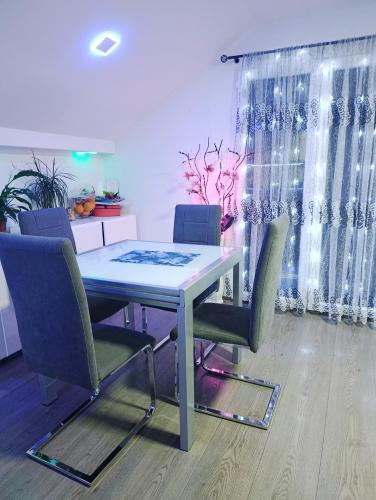 a dining room table and chairs in a room at Ambient Light apartment Sarajevo with free parking in Sarajevo