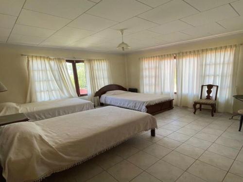 een hotelkamer met twee bedden en een stoel bij Hotel San Javier in San Luis