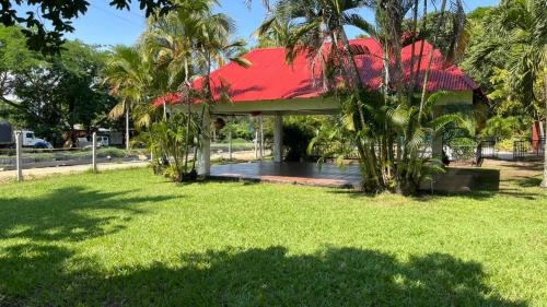 un pabellón con techo rojo en un parque en Restaurante - Hotel Los Manguitos, en Rivera