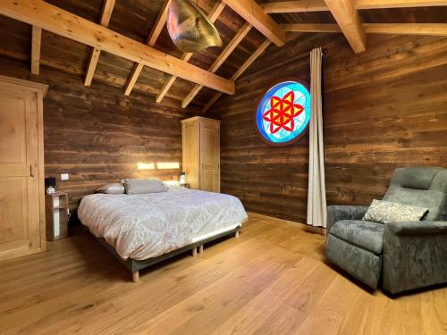 une chambre avec un lit et une chaise dans l'établissement Le Nid des Roches, à Saint Michel la Bâtie