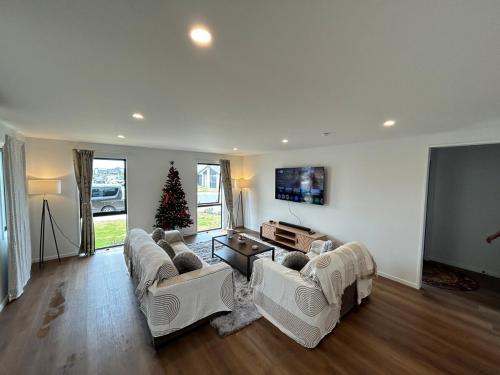 een woonkamer met 2 banken en een kerstboom bij Stackwood Lodge - Relaxed stay for all seasons in Woodend