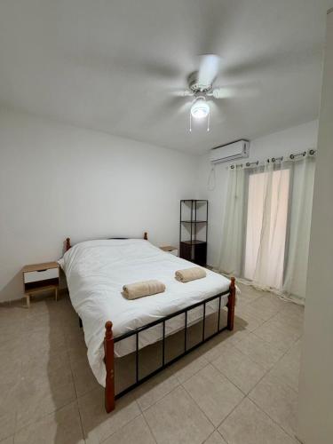 um quarto com uma cama e um ventilador de teto em חלון לצפון em Qiryat Shemona