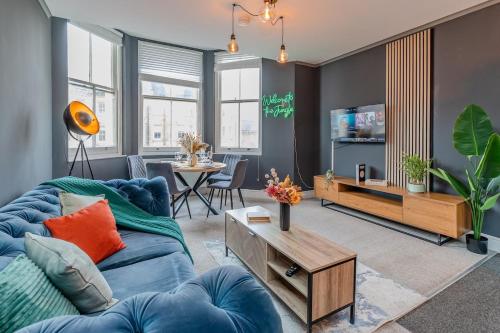 a living room with a blue couch and a tv at Seaview 3 bedroom Apartment Sleep 8 Guests in Brighton & Hove