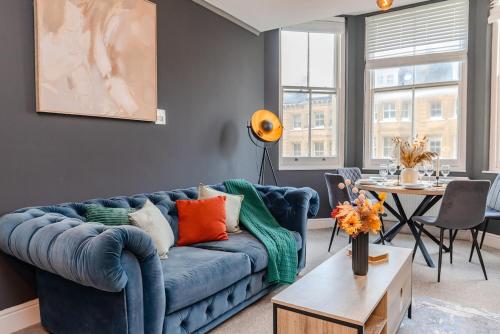 a living room with a blue couch and a table at Seaview 3 bedroom Apartment Sleep 8 Guests in Brighton & Hove