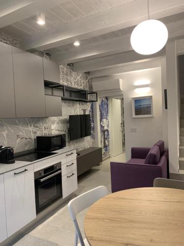 una cucina e un soggiorno con tavolo e sedie di Vela Living a Civitanova Marche